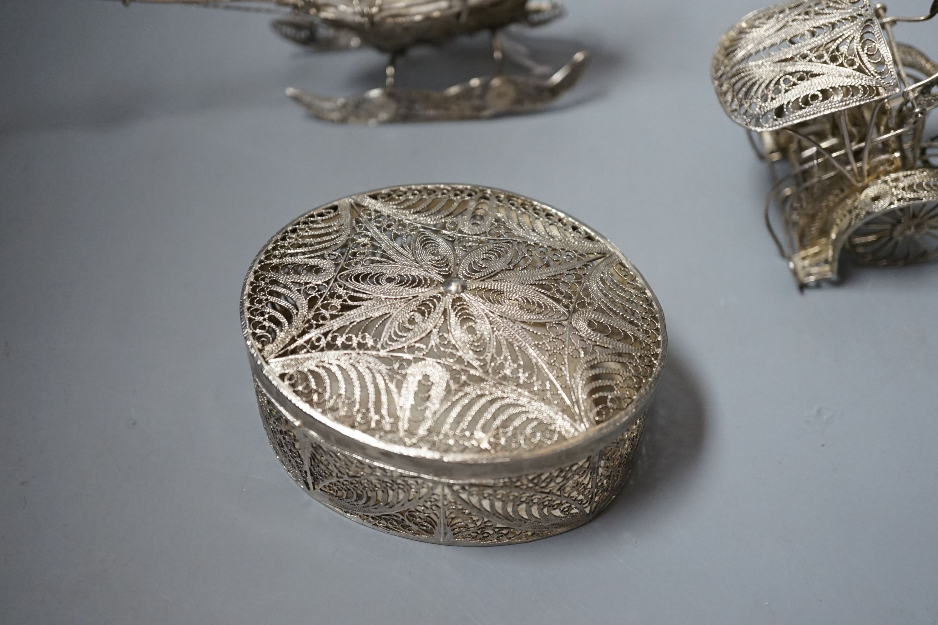 A Chinese filigree white metal model of a ship, length 19cm, a similar model of a rickshaw with driver and passenger and a similar oval box and cover